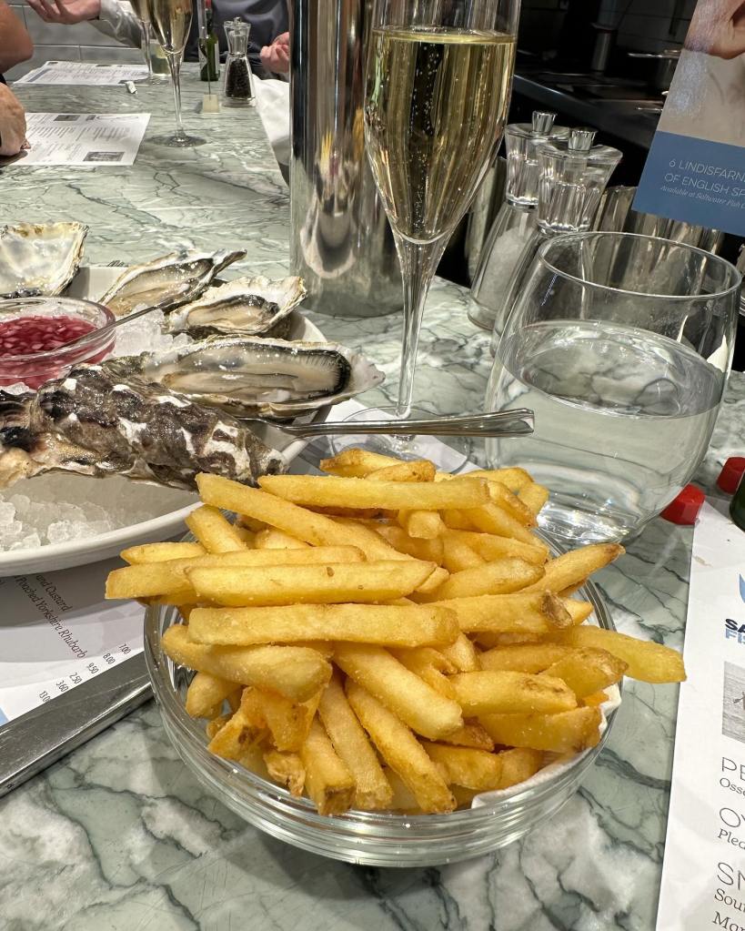 Crispy, golden fries served alongside fresh oysters at Saltwater Fish Company, Fenwick Food Hall