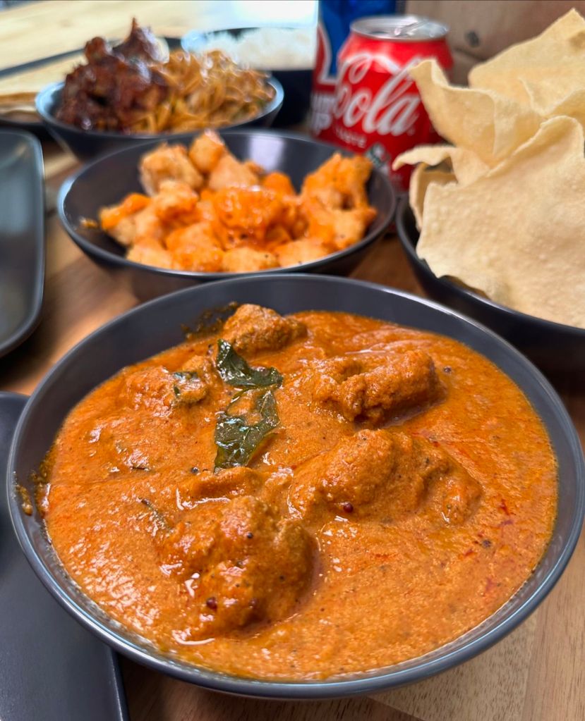 Dynamite chicken starter and station lamb curry with rice from Wok India, featuring depth of flavor and aroma