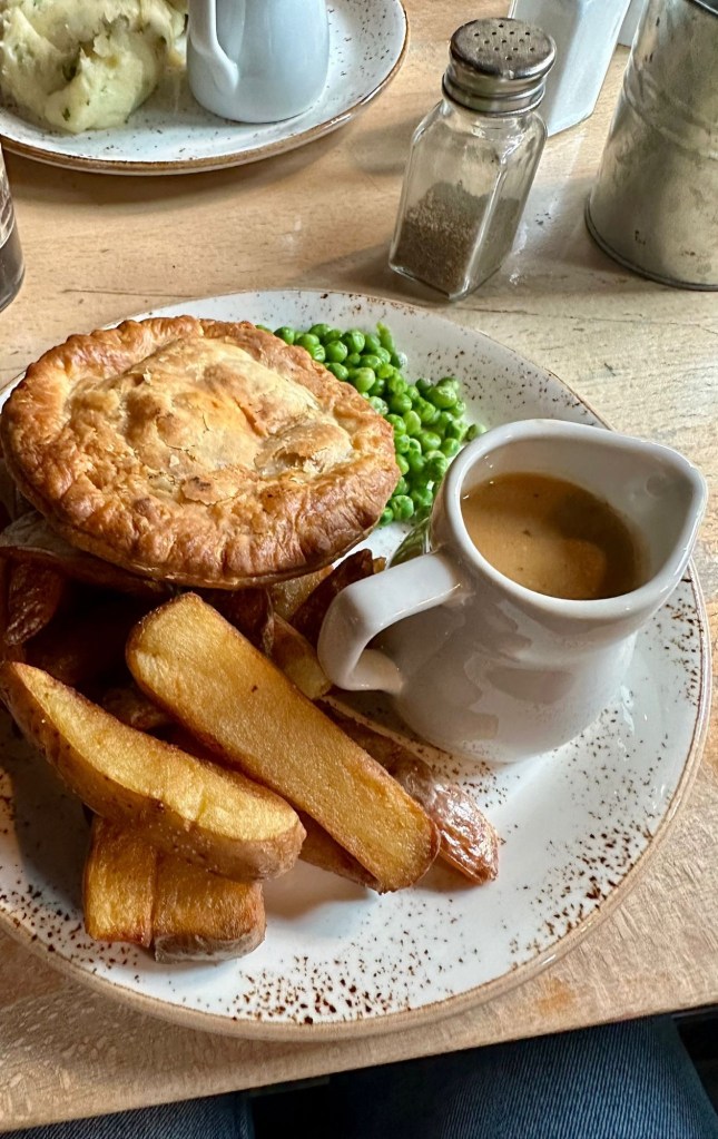 Generous serving of pie with chips and cheesy mash from The Redhouse, showcasing their extensive menu options