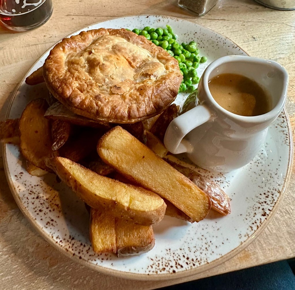 Generous serving of pie with chips and cheesy mash from The Redhouse, showcasing their extensive menu options