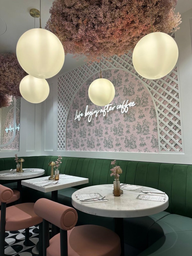 Café Interior: A stylish café space with light colors, modern lighting, neon signs, and lush greenery