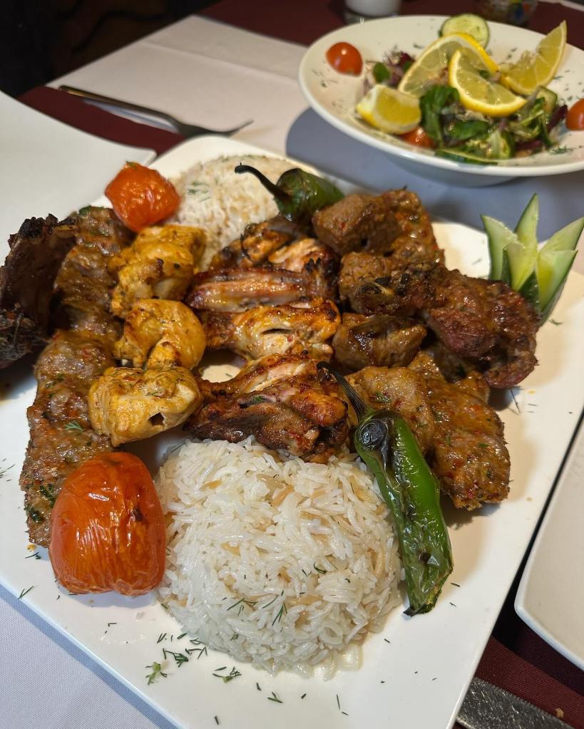 A sizzling hot platter filled with beautifully grilled meats, served with a side of fresh salad, showcasing the authentic flavors of Turkish cuisine