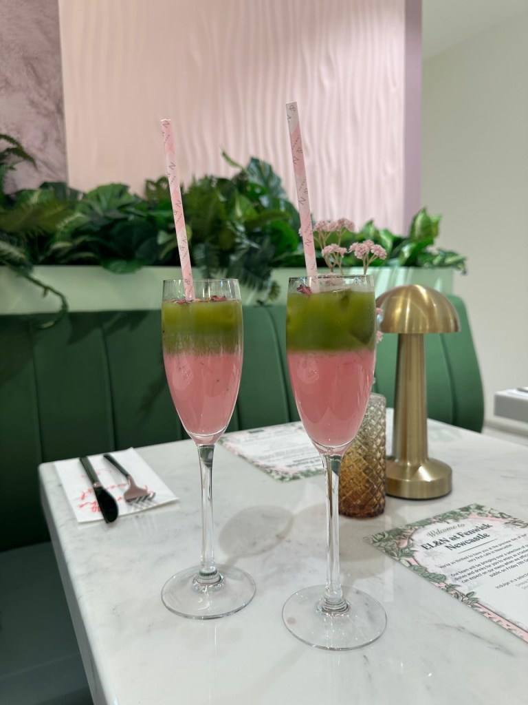 Rose Matcha, a colorful glass of pink and green garnished with rose petals