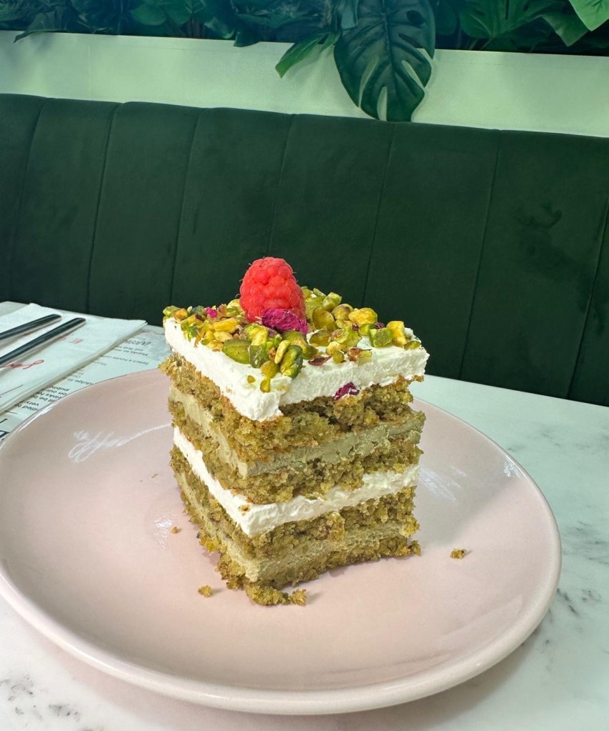 Pistachio & Rose Cake: A delicate, pastel green cake with layers of pistachio and rose cream, topped with rose petals and a sprinkle of pistachios.