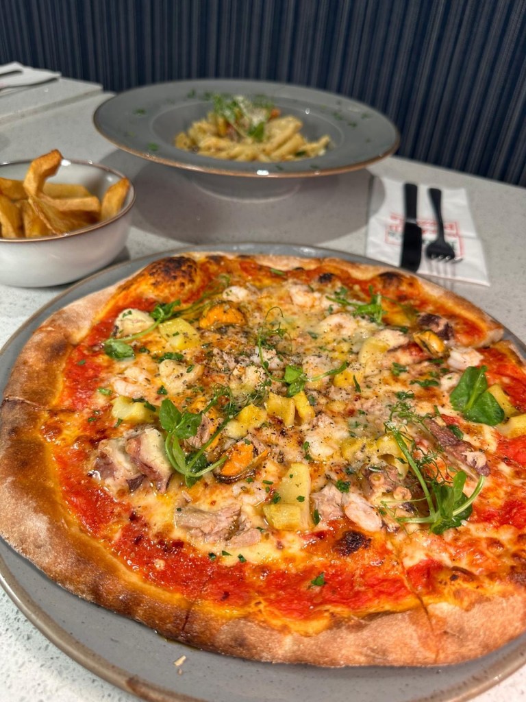 Pizza Pescaro: Seafood pizza topped with perfectly cooked seafood and a hint of spice at Mamas Bar and Grill, ideal for seafood lovers