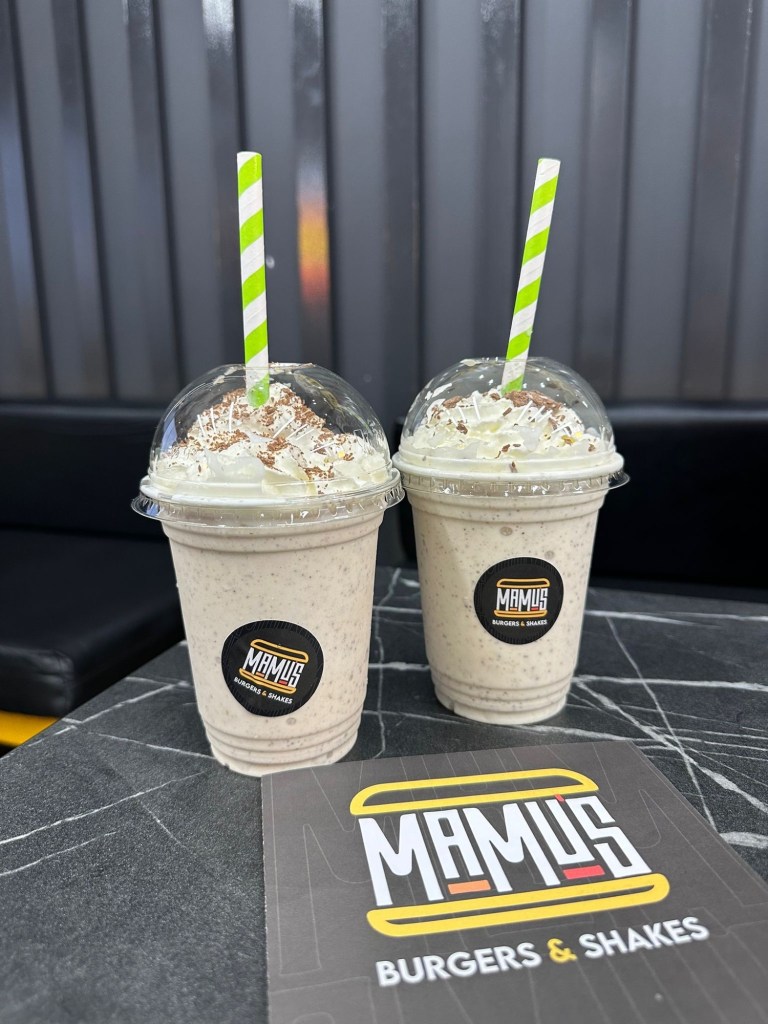 Go Bananas Shake: The Go Bananas shake served in a tall glass, topped with whipped cream and banana slices. Zillionaire Shake: The Zillionaire shake featuring chocolate and Ferrero Rocher toppings in an indulgent presentation