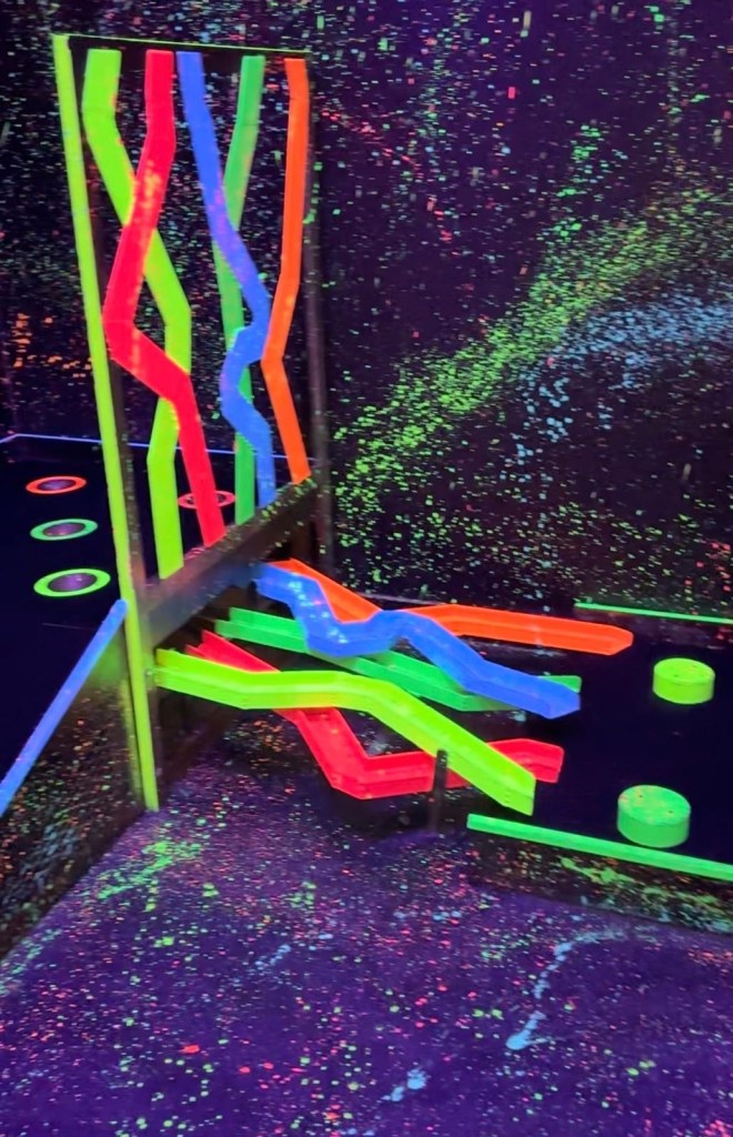 A vibrant, creatively designed golf course at Junkyard Golf Club, featuring quirky obstacles and interactive elements