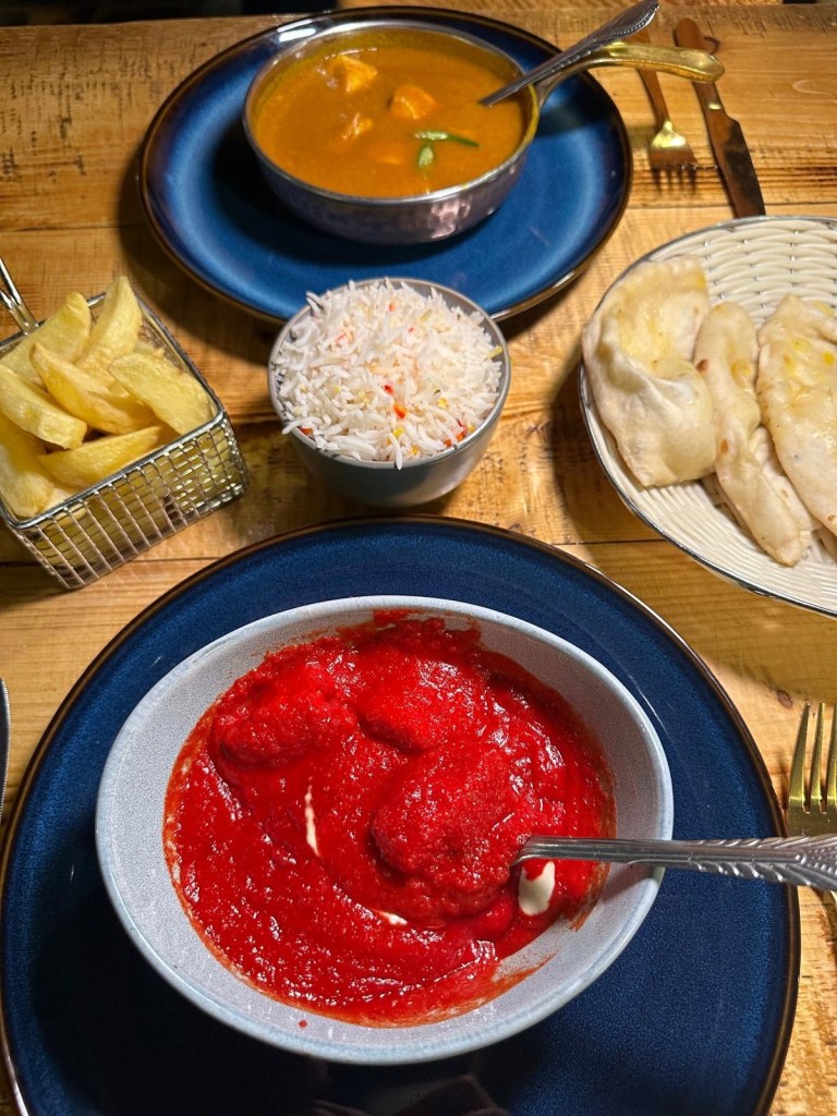A vibrant spread of Madras and Masala dishes served with Pilau Rice, chips and Garlic Nan at My Bombay Bistro