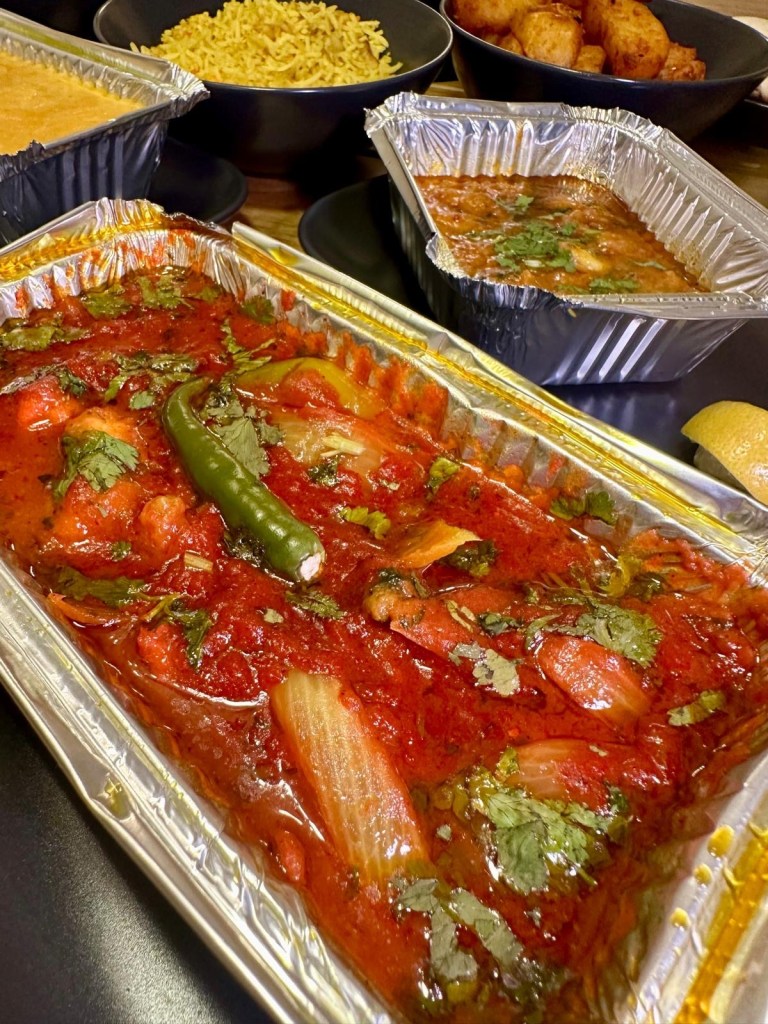 King prawns in a fiery jalfrezi curry with fresh vegetables and extra sauce.