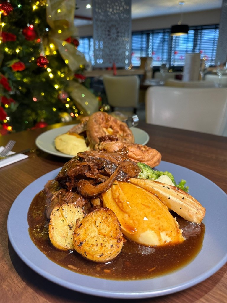 A hearty Sunday roast with tender topside of beef, Yorkshire pudding, crispy roast potatoes, buttery mash, and a medley of seasonal vegetables, topped with rich gravy