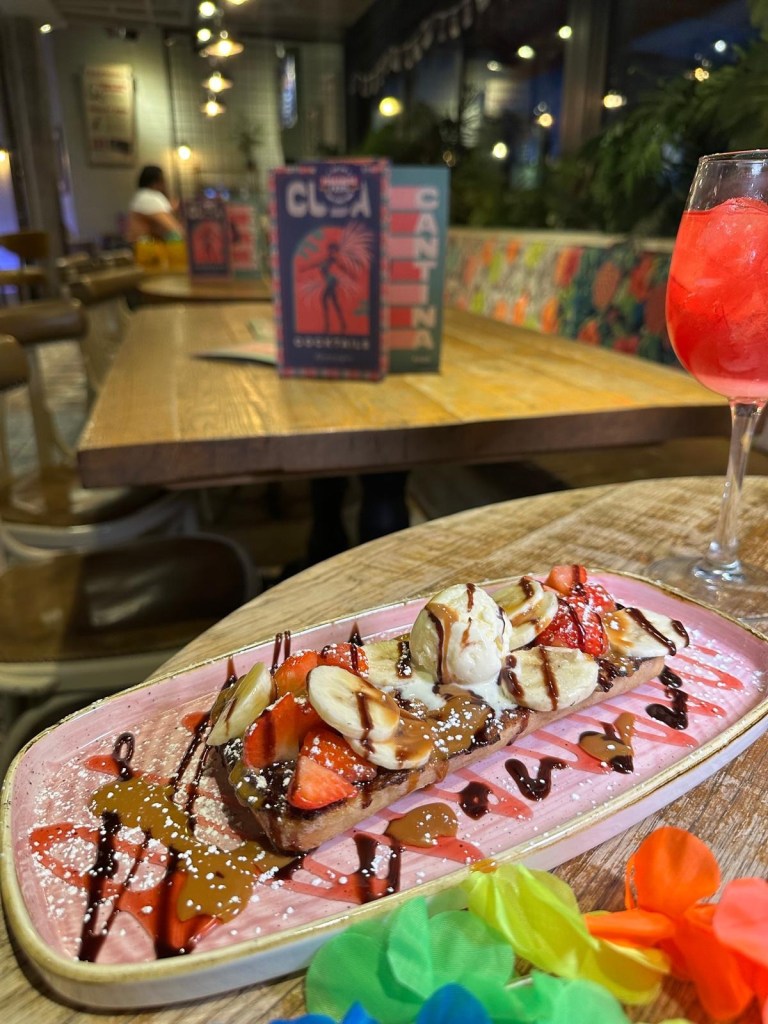 A spread of delicious dishes from the festive bottomless brunch at Revolution de Cuba, featuring patatas bravas, salsa and chips, and a sweet pancake stack topped with syrup and fruits