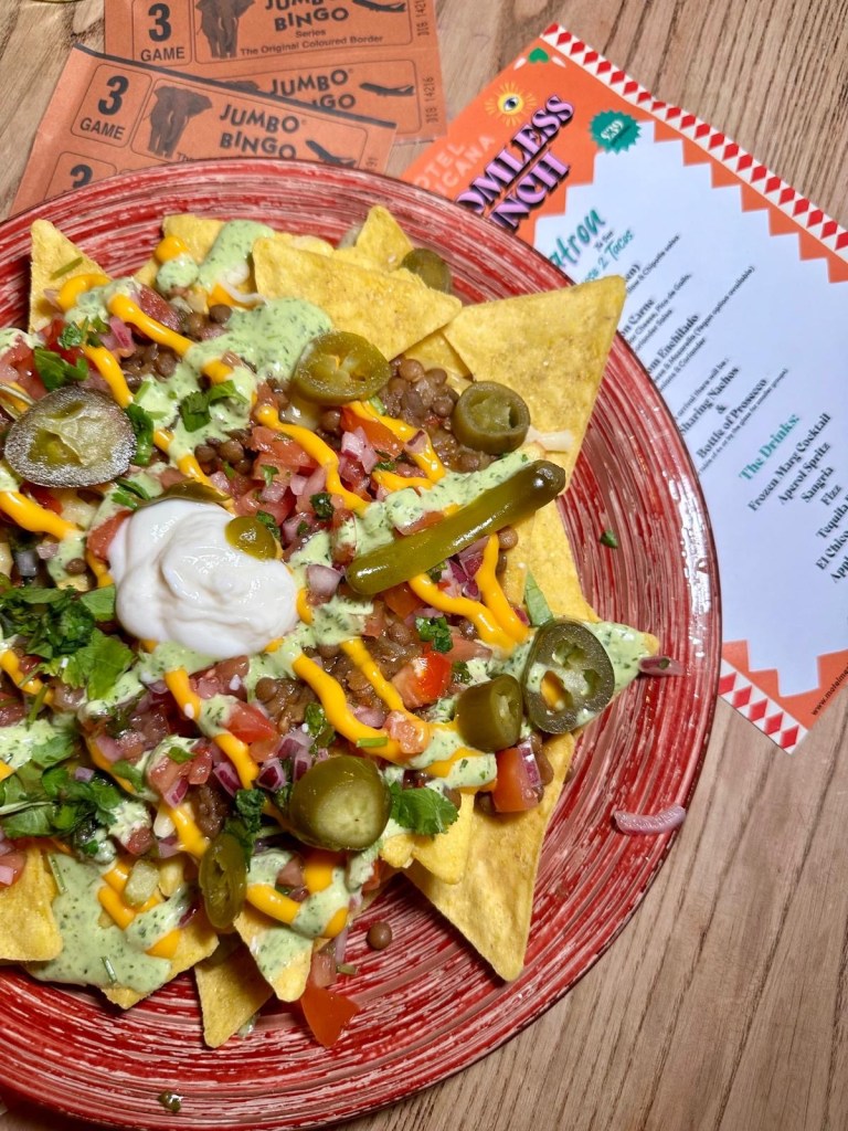 Loaded Nachos: A plate of loaded nachos piled high with melted cheese, fresh salsa, jalapeños, and guacamole.