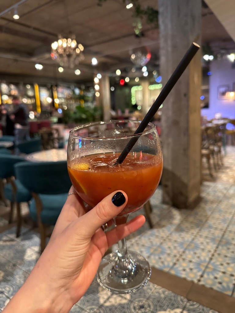A colorful selection of festive cocktails from Revolution de Cuba, including a Merry Cherry Cuba Libre, Strawberry Margarita, and a shot tray with spicy mango and raspberry garnishes