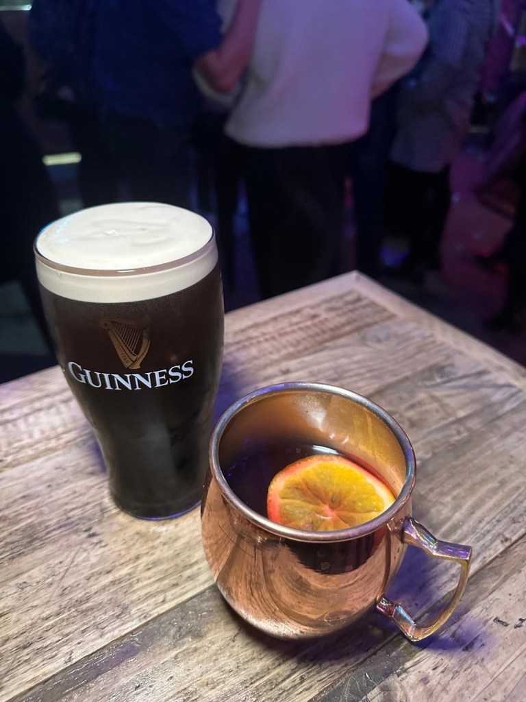 A pint of Guinness and mulled wine in a ski bar with rough sawn wood cladding, inviting warm atmosphere and a Christmas vibe