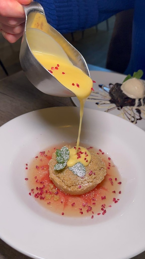 Warm seasonal fruit crumble topped with golden-brown crust and served with custard at Breeze Lounge