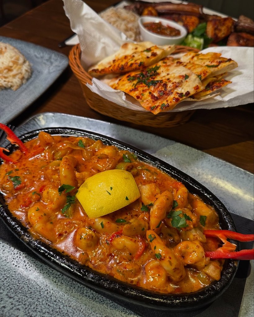 Pan-fried king prawns in a creamy tomato sauce with onions, peppers, and mushrooms, served with fluffy rice and flatbread at Saray Turkish Restaurant, Jesmond.