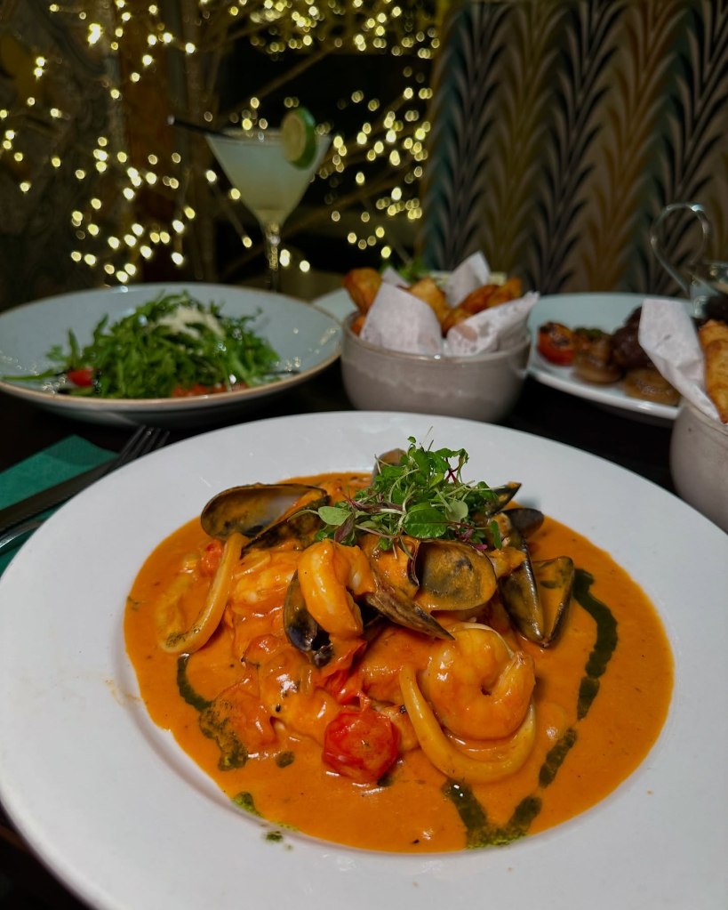 A vibrant seafood dish featuring mussels, prawns, and squid in a rich sauce at Fabio’s Italian Restaurant.
