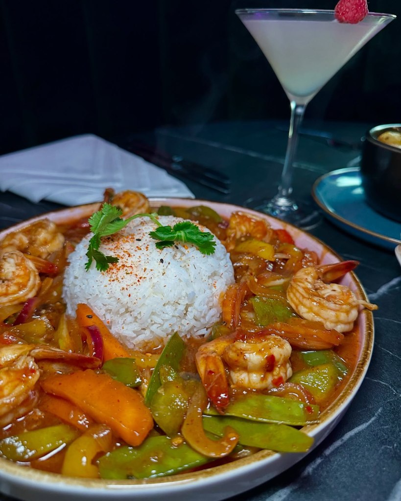 King Prawn Firecracker with prawns, peppers, onions, mange tout, and red chillies served with sticky rice.