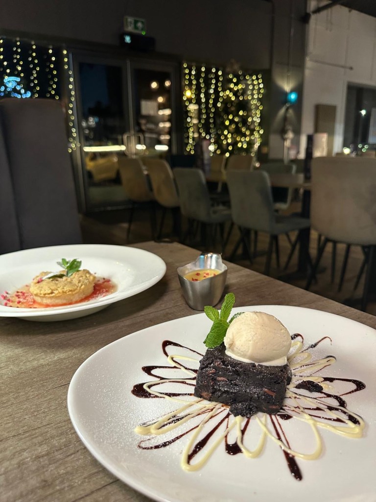 Rich chocolate brownie served with vanilla ice cream and a drizzle of chocolate sauce at Breeze Lounge