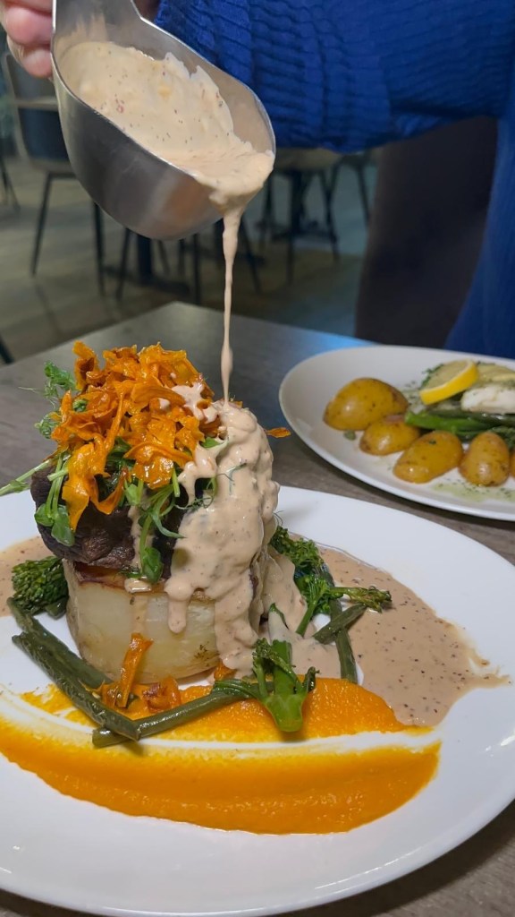 Slow-cooked beef with fondant potato, buttered greens, and peppercorn sauce at Breeze Lounge