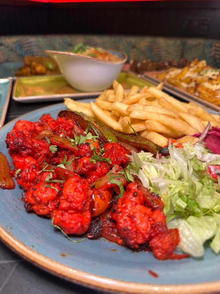 A skewer of marinated king prawns, grilled to perfection, served with a vibrant side salad