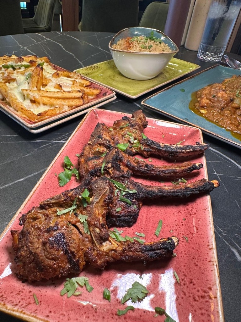 Tender grilled lamb chops, beautifully charred, served on a plate with garnish