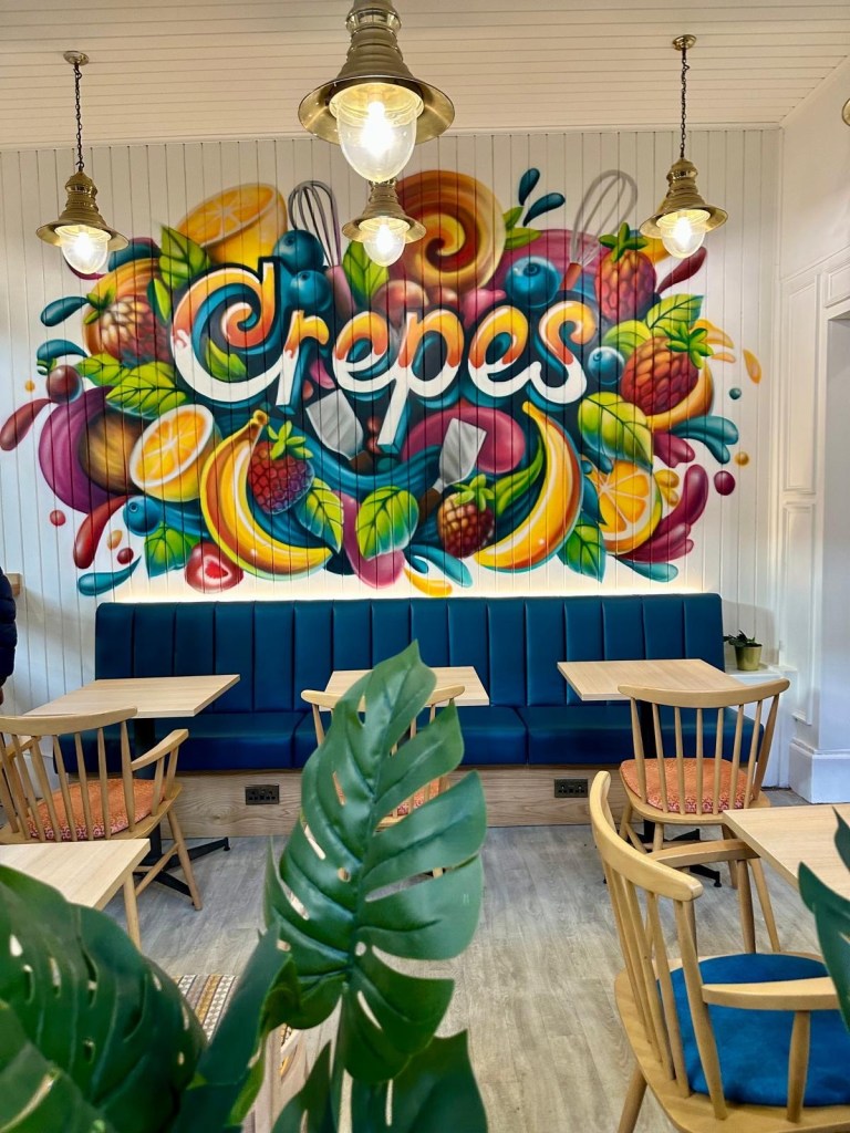 Crepes Gourmet – gourmet crepes in the North East If you’re after some delicious, French inspired crepes in the heart of Newcastle, Crepes Gourmet in Grainger Market is the place to try. Their menu offers a fantastic, in my opinion, mix of sweet and savoury crepes, each freshly made to order, with top quality, fresh ingredients. The menu has all of the classics we love like Nutella and Banana, and Lemon and Sugar, as well as some more unusual, and even savoury options that got me really excited – like a Spicy Popeye (you can guess what's in that one!). Crepes Gourmet’s mission is: ‘Life is too short not to eat something good every day’ and I couldn’t be on board with that any more! What we had: In the name of research, as always, we had to try both the sweet and savoury options, and it was a great shout. Pistachio This crepe was an absolute sweet treat. The Sicilian pistachio spread was rich and creamy, with the crushed pistachios adding some lovely scrunch. The tartness of the raspberry flakes balanced the richness of the pistachio, and the fresh strawberries were the perfect finishing touch (I think strawberries are such a natural fit for crepes, whatever other toppings you go for). It was simply delicious. Romana This was our savoury choice and it was GORGEOUS! The mozzarella and cheddar gave it a melty texture, while the tomato pesto brought a zesty kick (which I loved!) The combination of creamy, cheesy, and tangy flavours inside a warm, soft crepe was something else – I could definitely see myself coming back for this one time and time again. I usually go for a savoury crepe over a sweet one whenever I see one on the menu, and I found theirs to be very different from others I’ve had in the past (and by that, I mean it was more savoury, somehow). When I had a little chat with Marian, the owner (who I also the chef making the crepes), to tell him how much I enjoyed the food, he mentioned that they actually use different batter for the sweet and savoury crepes, which explains why it was so delicious. Why we enjoyed our visit • The friendly staff made the visit feel special, and their service was top-notch. • Despite being busy, the crepes were served up quickly without sacrificing quality – they were fresh and hot. The presentation was also lovely. • Watching the crepes being freshly made was such a fun experience – it's always nice to see your food prepared right in front of you – I always find it to be a highlight, not to mention you can see how pristinely clean and tidy the place is. • We learned that they use a separate batter for their sweet and savoury crepes, and it really made a difference. No idea how they do it but it works - I guess it is a secret that sets them apart. If you enjoy crepes and pancakes, this place is really worth a try. The setting is lovely and staff couldn’t be any more helpful. There are so many flavours to try, both sweet and savoury, so even though it is all about the crepes, it would be impossible to get bored of the menu as there’s loads to try. Their coffee is also delicious. They only started in 2022, but the hype about this place is real! Location: Crepes Gourmet is located at Alley 4, 173-175 Grainger Market, Newcastle upon Tyne NE1 5QQ. The nearest metro station is Monument, just a short walk away. We usually park in the Dean Street multistorey and enjoy a little walk to the market – it definitely helps us work up an appetite before all the delicious crepes and treats. Tips for visiting: Be mindful of their opening times: o Tuesday–Saturday: 9 am–5:30 pm Don’t miss out on trying both their sweet and savoury crepes. They’re both incredible, but the flavours are distinct, so you’re in for a real treat whether you have a sweet tooth, or prefer savoury food. Especially if you’re like us two – both like entirely different flavour profiles. They also do lovely coffee, so even if you don’t fancy food, you can pop in and grab a coffee to take away, or to sit in in their lovely seating area (the wall art and greenery really makes this place feel nice and peaceful, even though you are right in the middle of a busy market). There is something for everyone with veggie, vegan and gluten free options available If you don’t normally go to the Grainger Market, you can catch them at local festivals and markets, like Seaham Food Festival, Quayside Market, Heaton Festival, Sound Wave Festival, Clubland by the Sea in Hartlepool, and Jesmond Food Market. Link For their full menu, specials, and any offers, visit their website here, you can also follow them on their socials for updates and behind the scenes fun! Reviews Crepes Gourmet have a fab 5 star rating on Google Reviews with customers praising the freshness of the crepes and the delicious flavours. Best for: desserts, Newcastle city centre dining, Grainger Market food, cafe