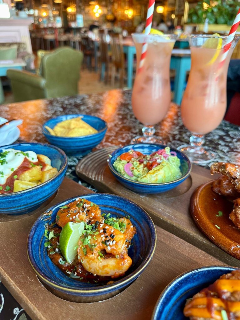 Korean king prawns drizzled with ssamjang sauce, lime juice, and sesame seeds on a white plate