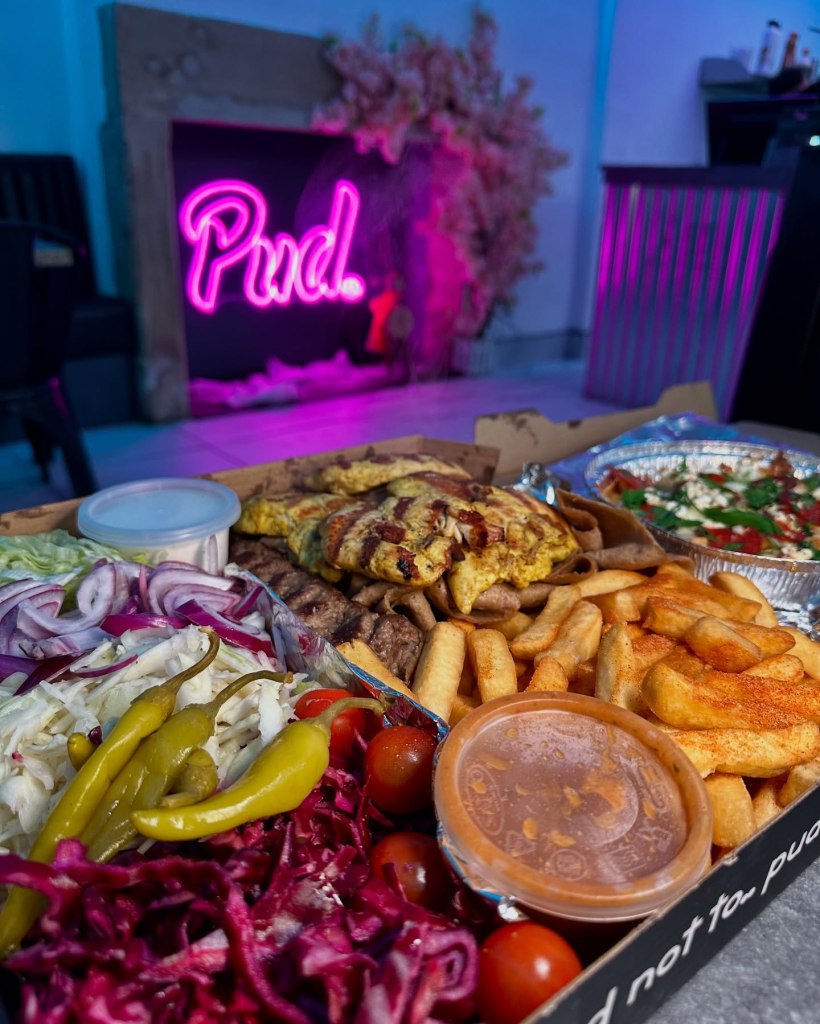 A generous naanbab kebab box with chicken, kofteh, and donner kebabs, salad, fries, and dipping sauces