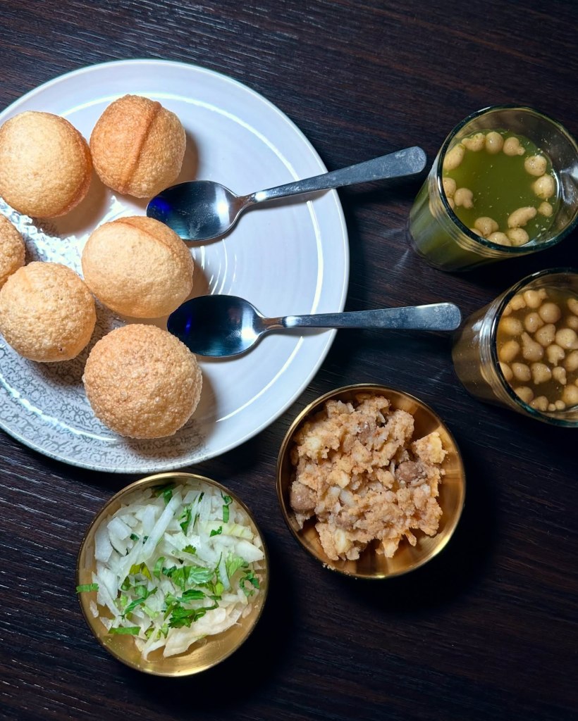 Pani Puri starter featuring crispy shells, spiced potatoes, chickpeas, and tangy pani sauce
