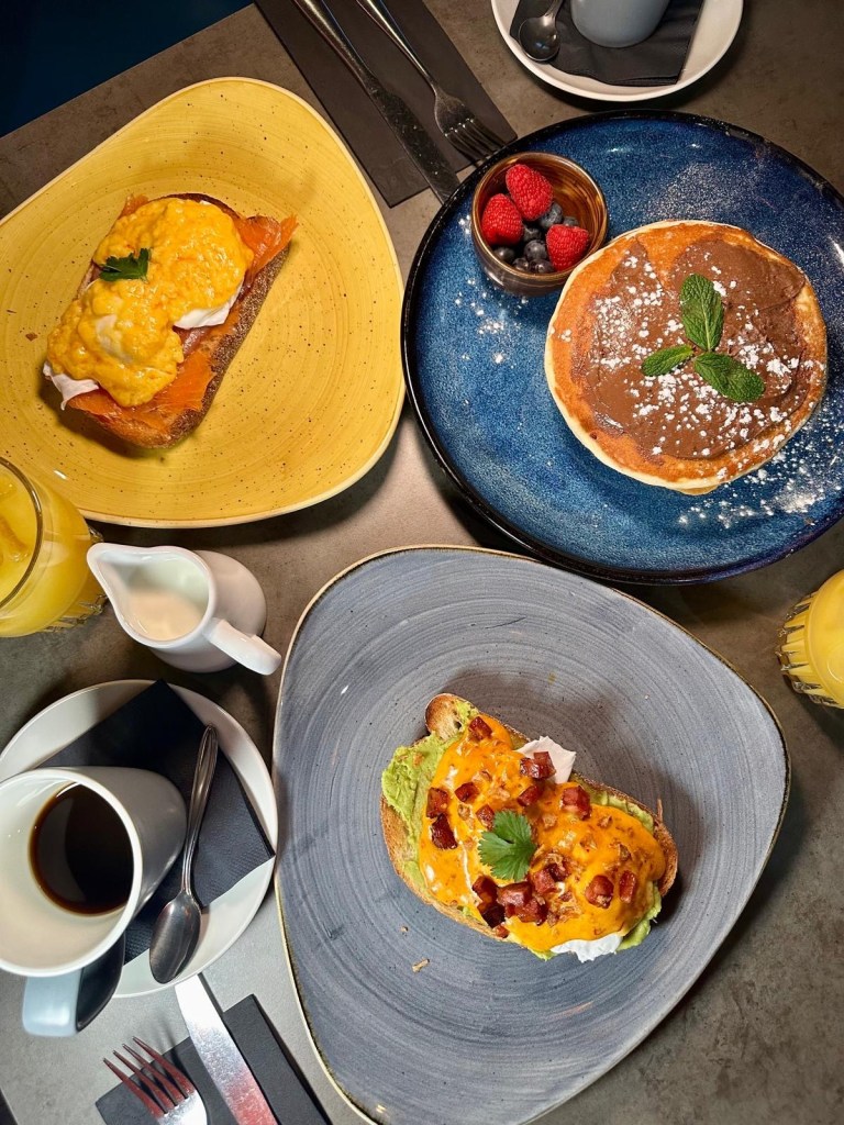 Geisha Fusion breakfast menu with fusion eggs, eggs royale, American pancakes, and cappuccino