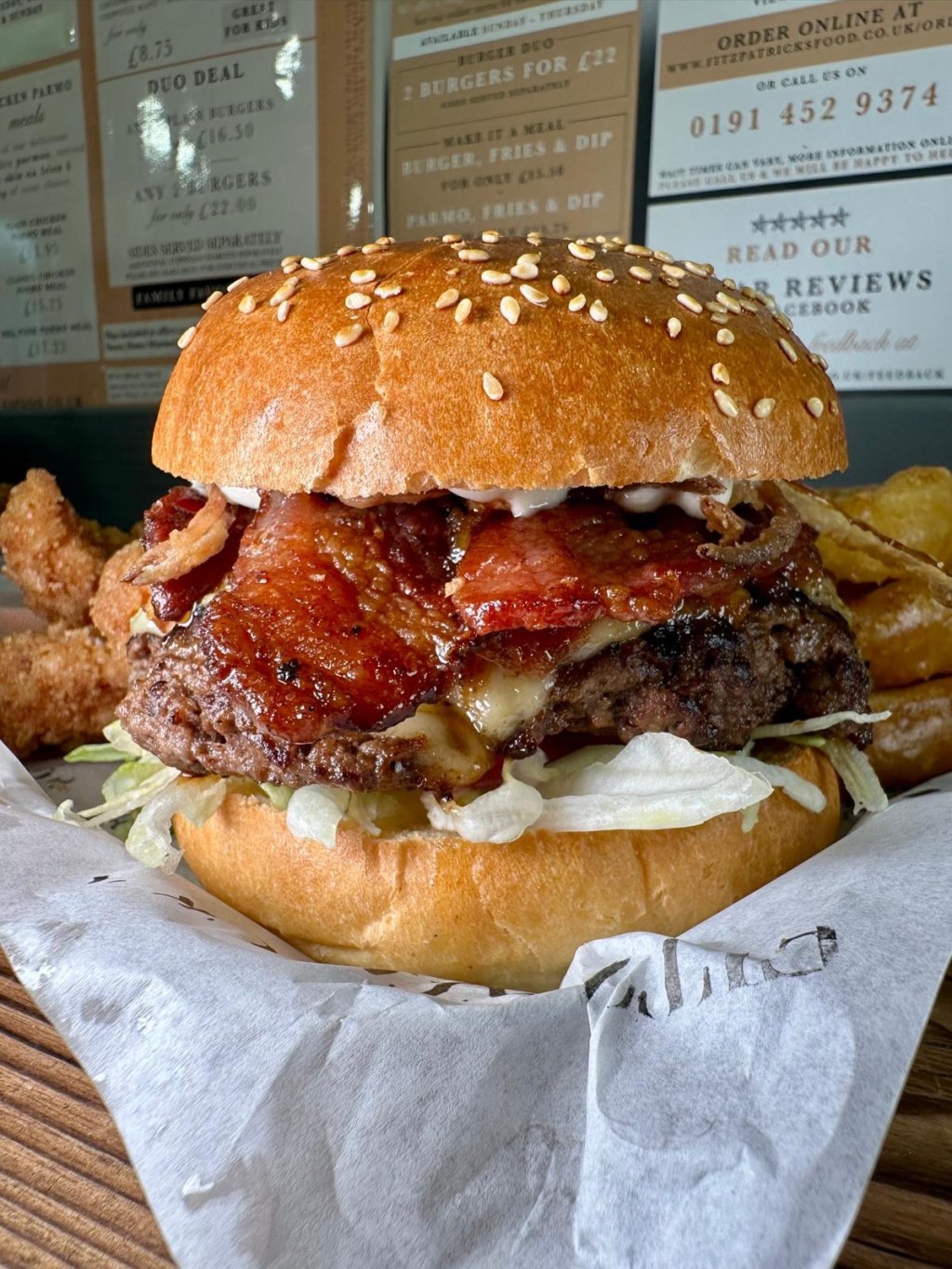 A massive Spicy Chipotle Burger loaded with jalapeños, crispy bacon, and smoky chipotle mayo, stacked high on a fresh brioche bun.