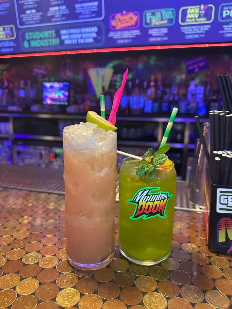 A bold green cocktail infused with matcha, tequila, and Mountain Dew, served in a sleek glass with a citrus garnish at NQ64 Newcastle.