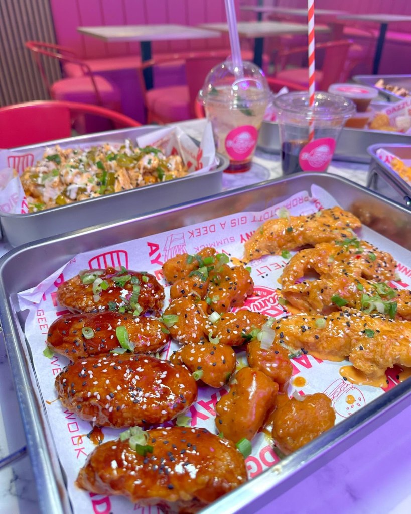 A plate of crispy, saucy chicken wings at Dream Burger, available in different spice levels.
