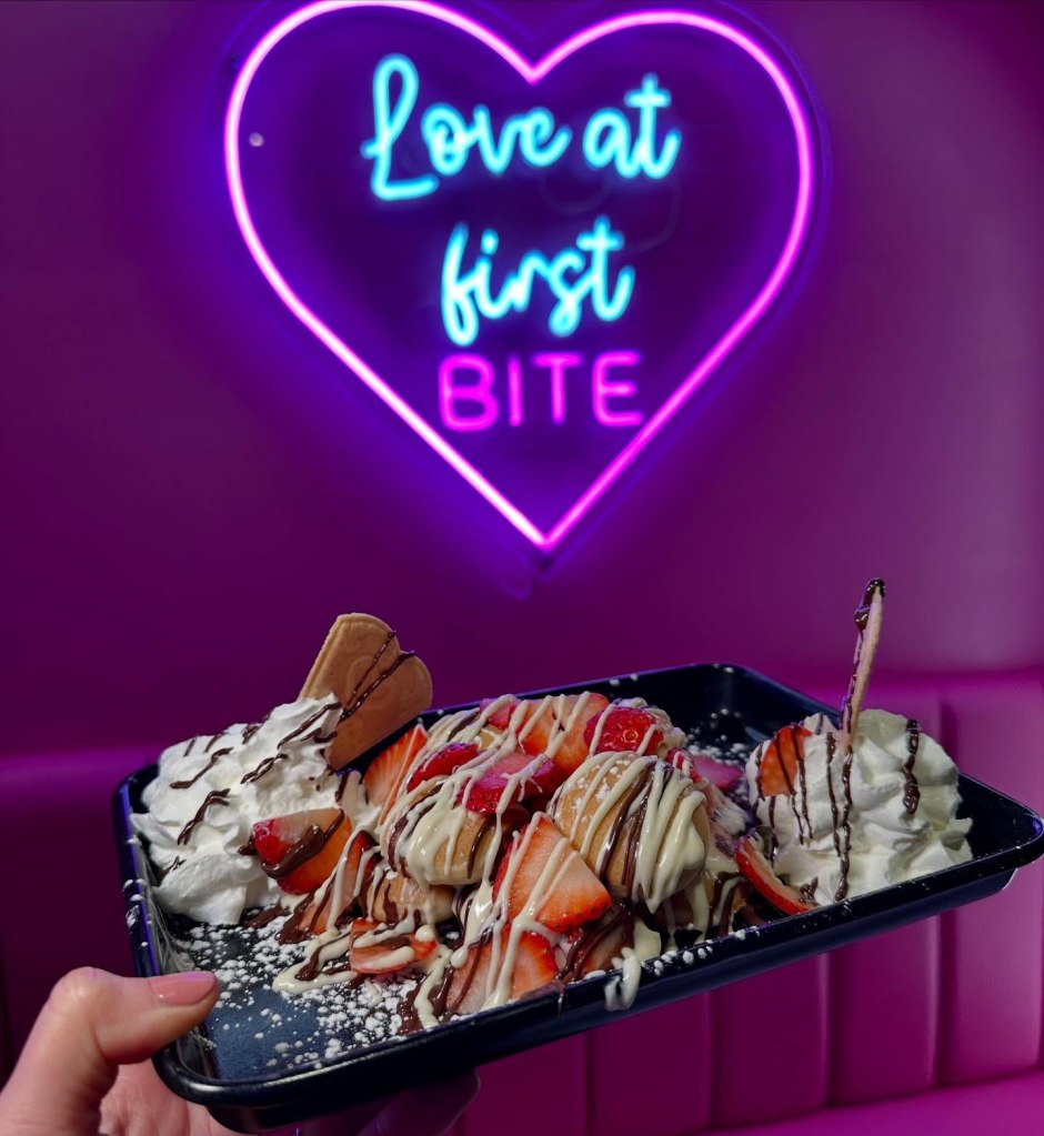 Fluffy waffle bites covered in chocolate and fresh strawberries, served with cream on the side