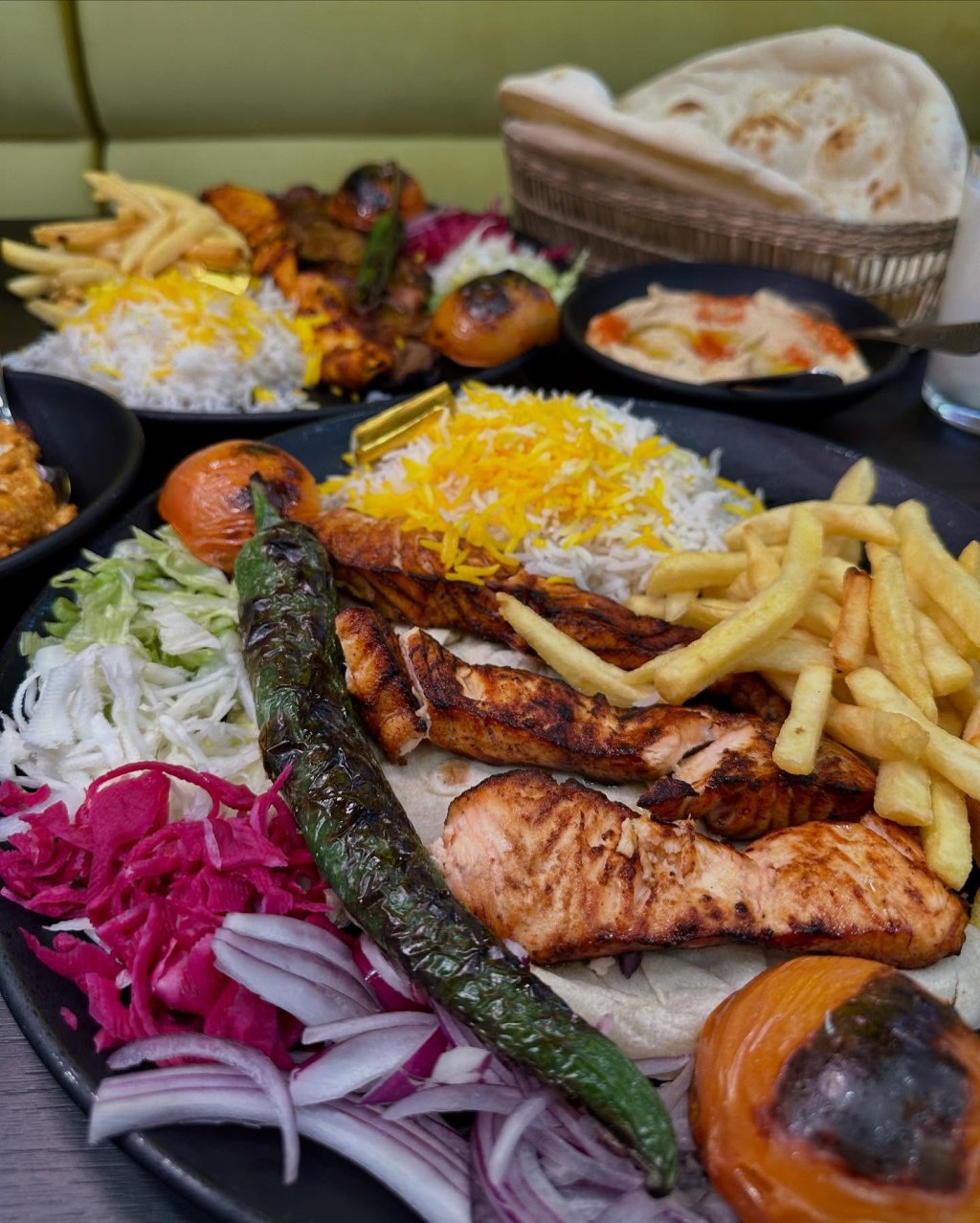 A plate of chargrilled salmon with crispy skin, served with grilled vegetables and fresh salad.