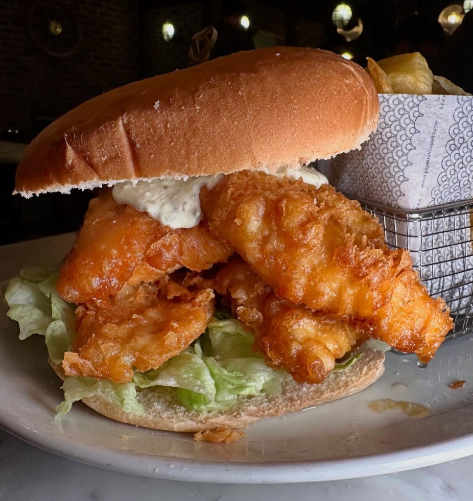 Massive fish finger sandwich with golden crunchy fish, soft bread, and tangy tartar sauce at Fisherman’s Bay.
