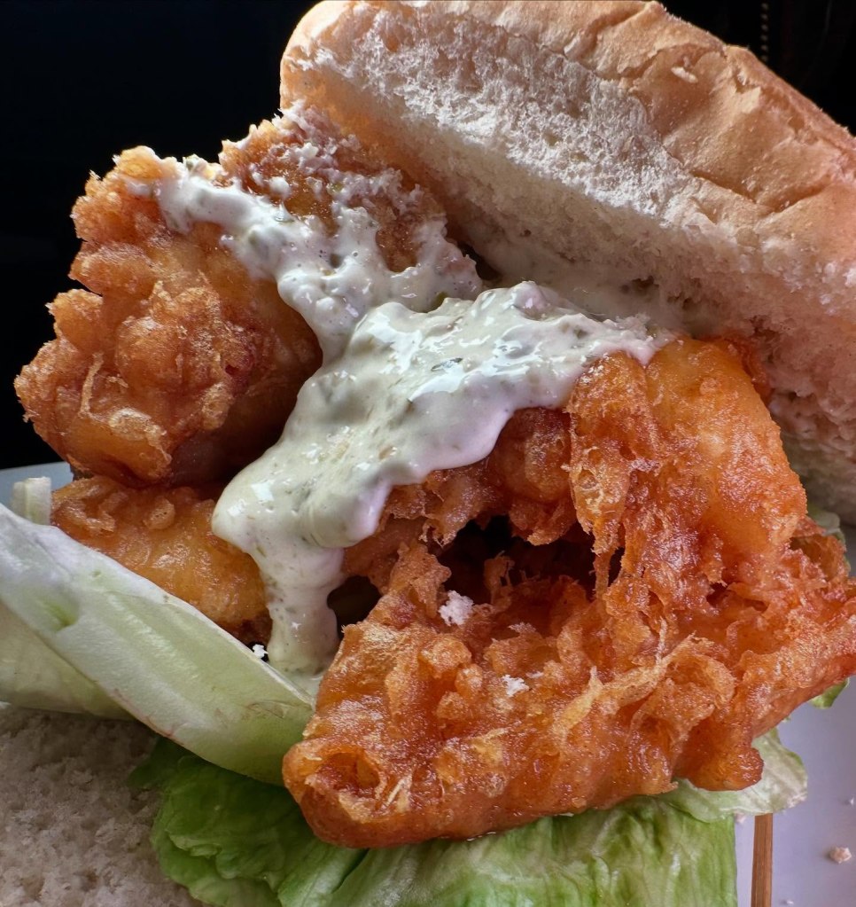 Massive fish finger sandwich with golden crunchy fish, soft bread, and tangy tartar sauce at Fisherman’s Bay.