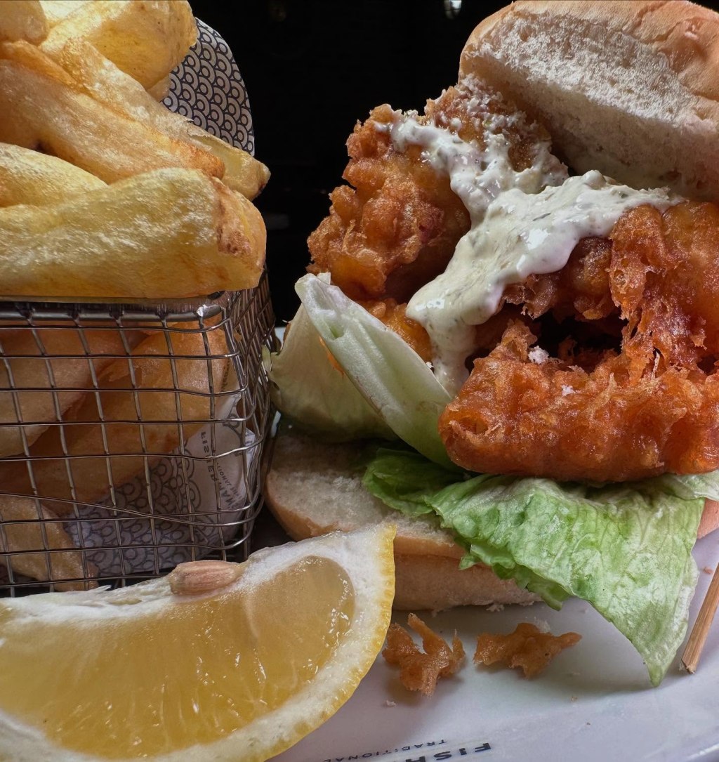 Massive fish finger sandwich with golden crunchy fish, soft bread, and tangy tartar sauce at Fisherman’s Bay.