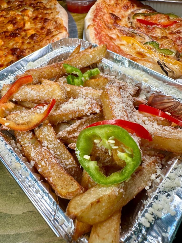 A portion of golden, hand-cut fries sprinkled with Cajun seasoning and parmesan cheese.