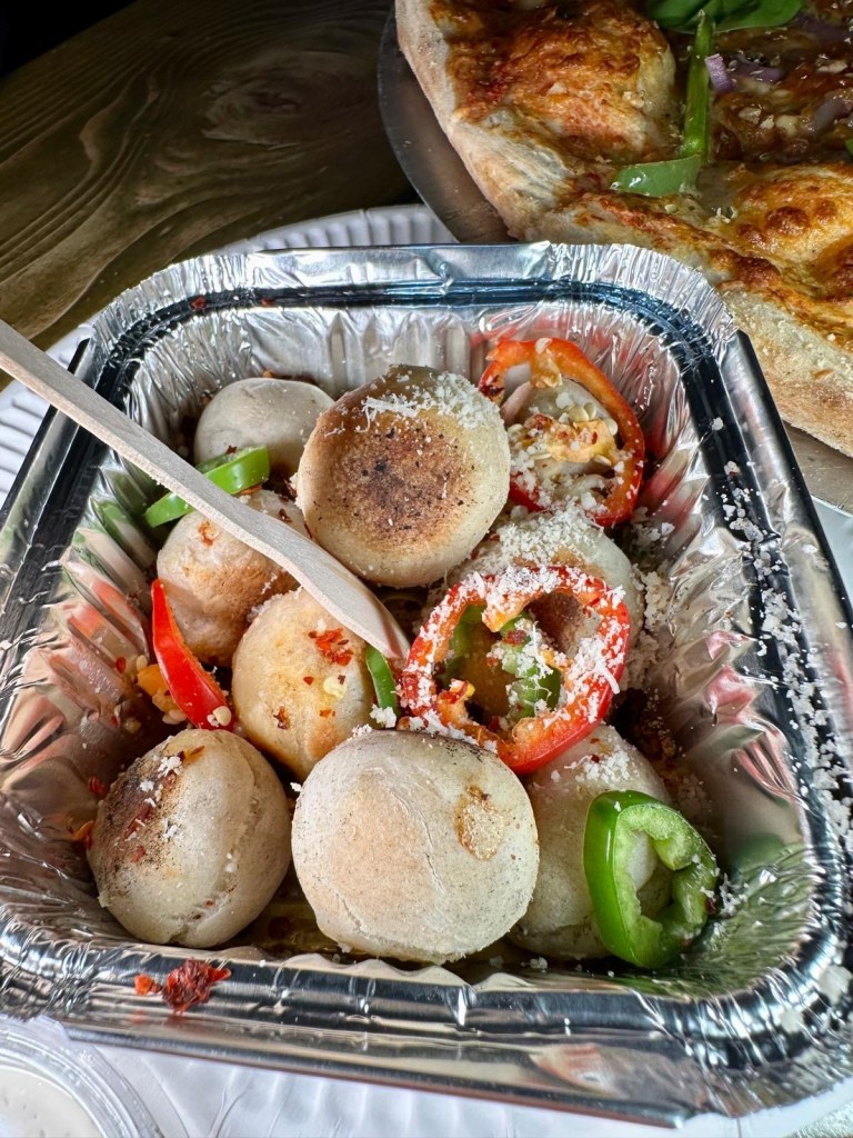 Soft and fluffy dough balls coated in fiery chili flakes, served as a spicy side dish.