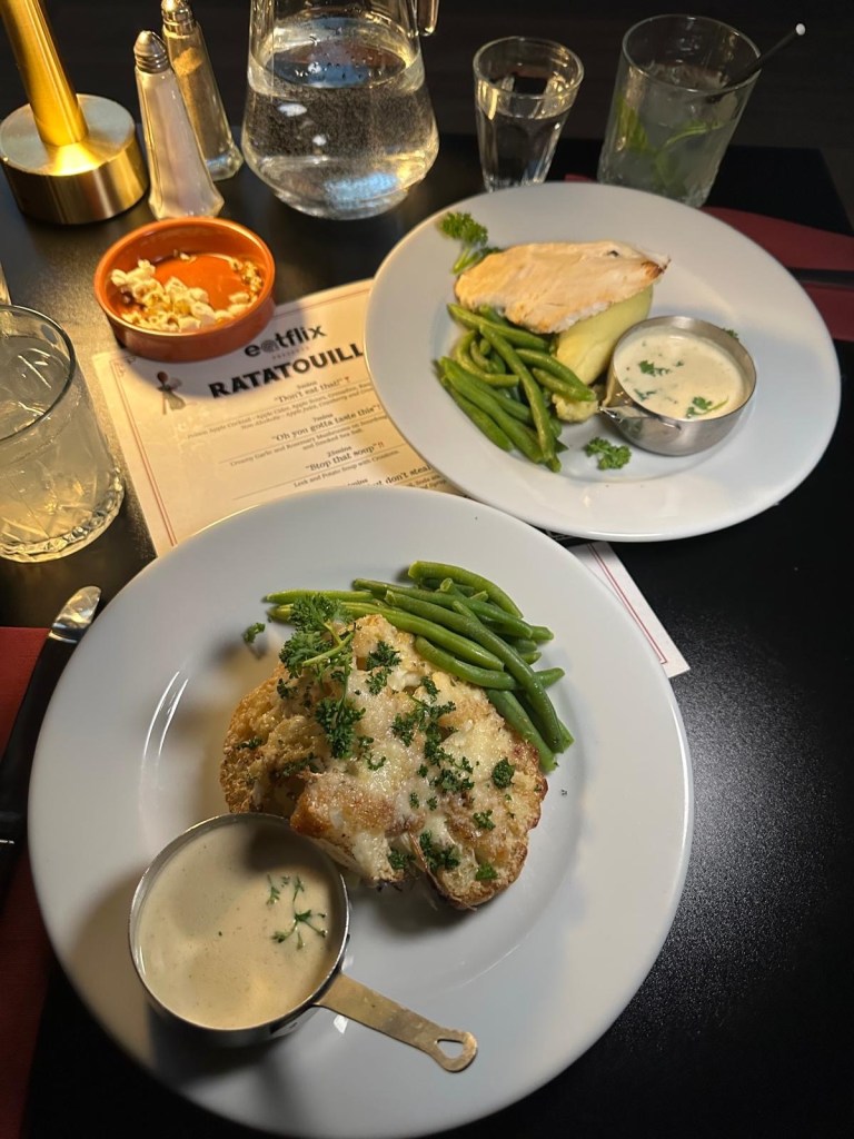 A plate of perfectly cooked chicken breast on creamy potato purée, drizzled with white truffle sauce and served with fresh green beans.