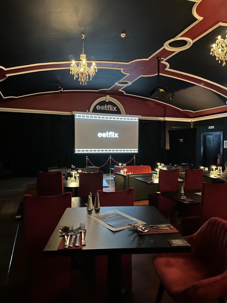 A stylish movie-themed venue featuring classic cinema posters and vintage-inspired decorations.