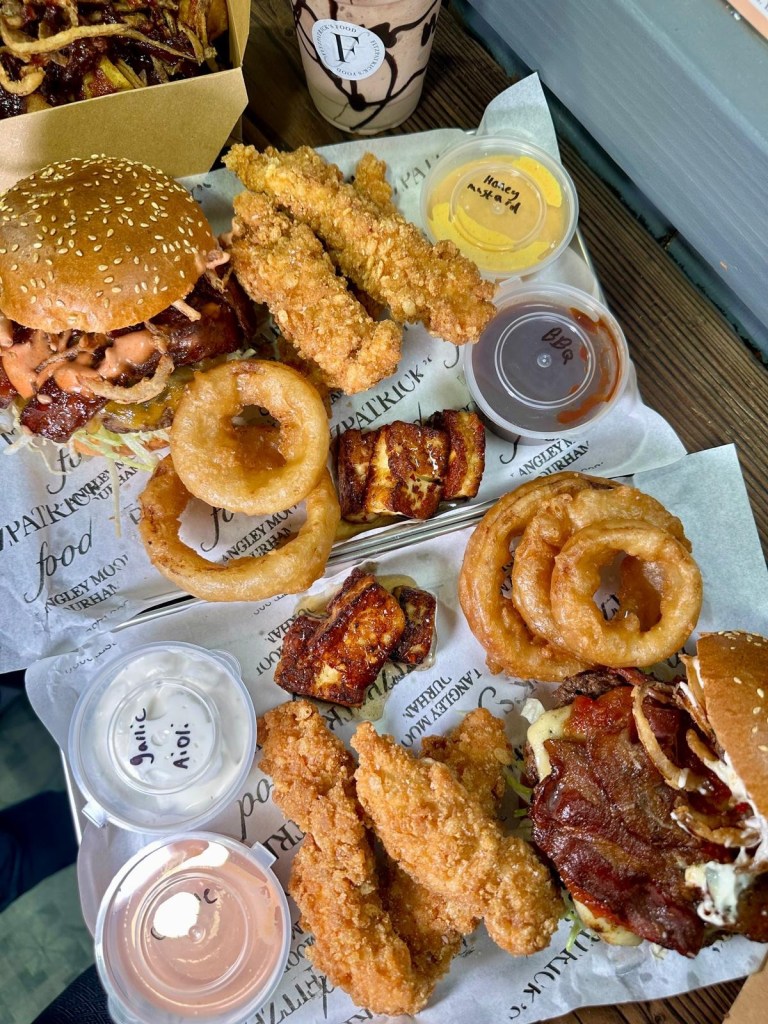 A feast of gourmet burgers, loaded fries, crispy chicken goujons, onion rings, and signature dips served at Fitzpatrick’s Food in Durham.