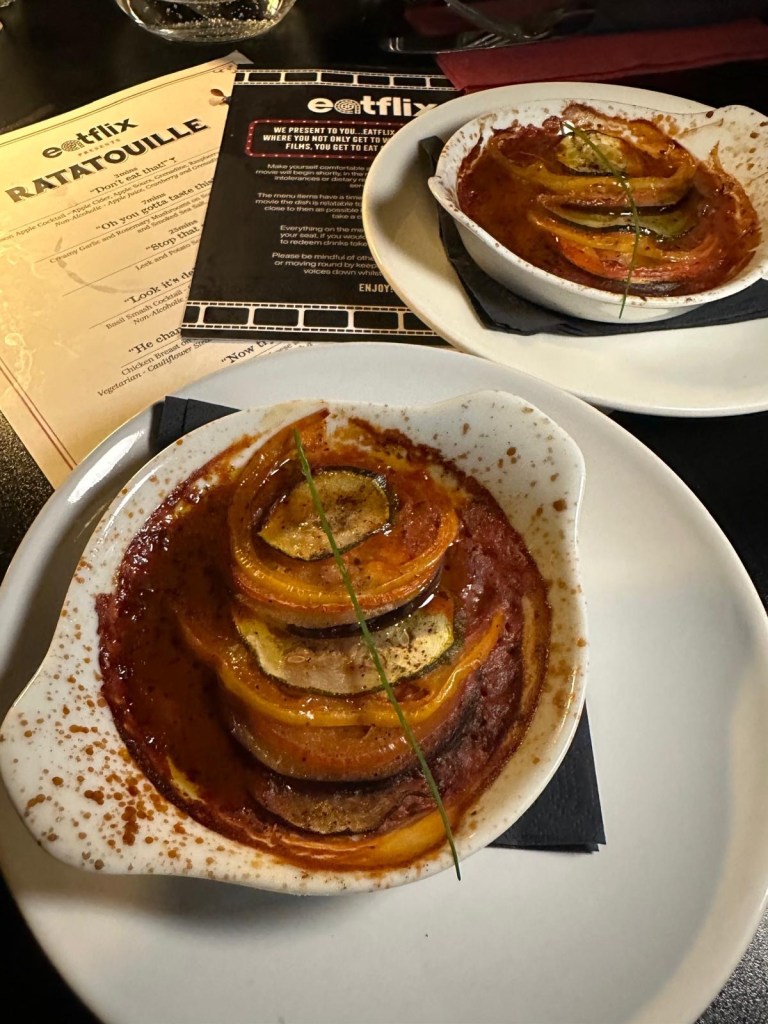 A colorful plate of classic French ratatouille with layers of thinly sliced vegetables in a rich tomato sauce.