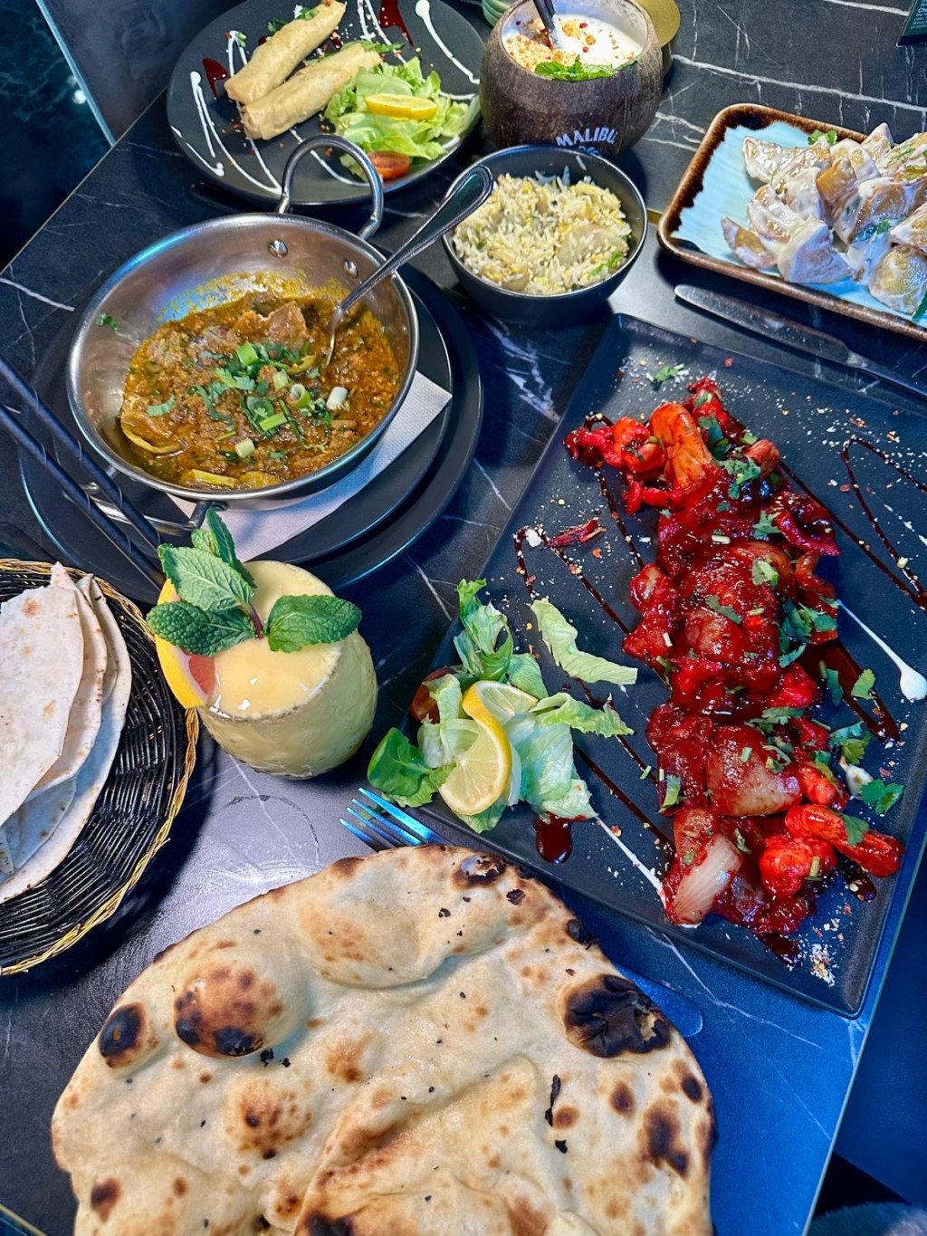 Large king prawns cooked with tamarind, garlic, honey, chili, and turmeric, served with warm, thin bread for dipping.