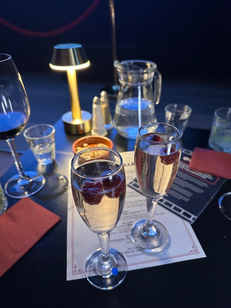 A chilled glass of prosecco with a fresh raspberry floating on top.