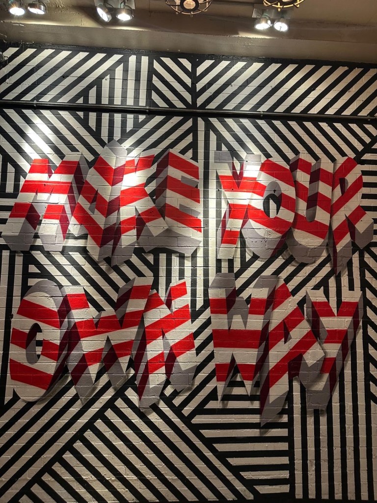 A retro-style gaming area featuring arcade machines, pool tables, and a neon-lit ambiance.