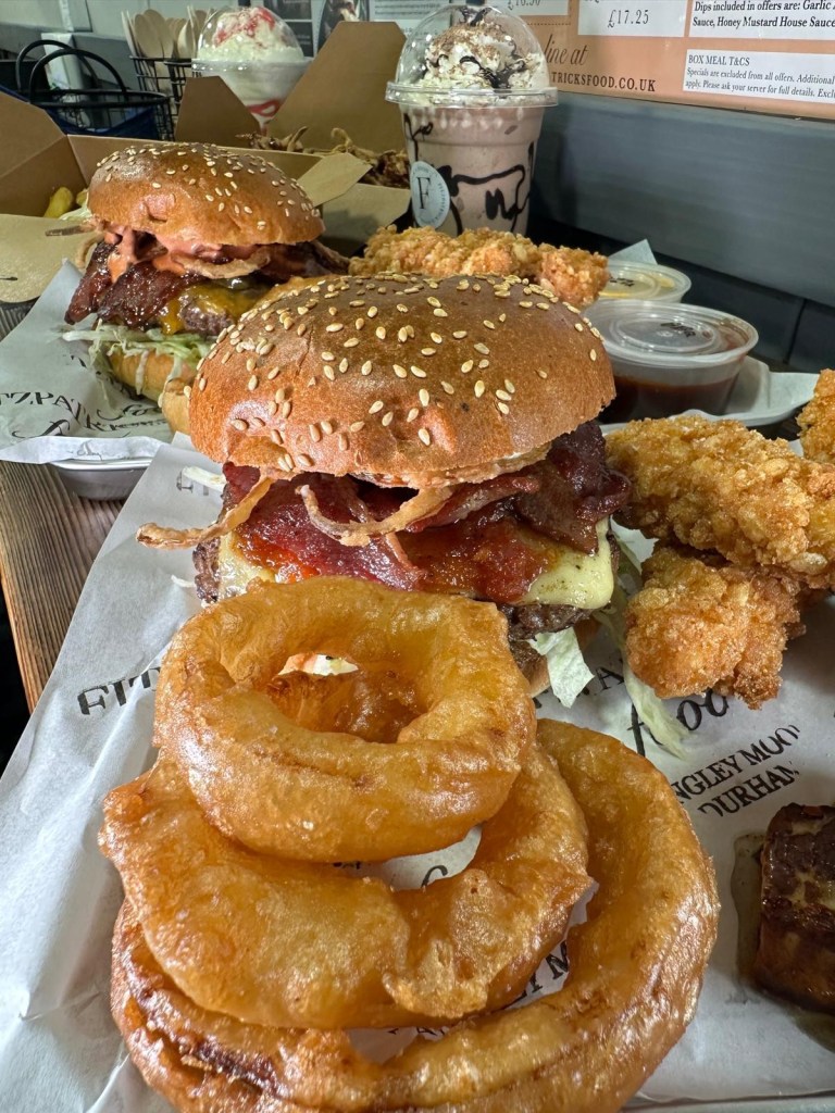A feast of gourmet burgers, loaded fries, crispy chicken goujons, onion rings, and signature dips served at Fitzpatrick’s Food in Durham.