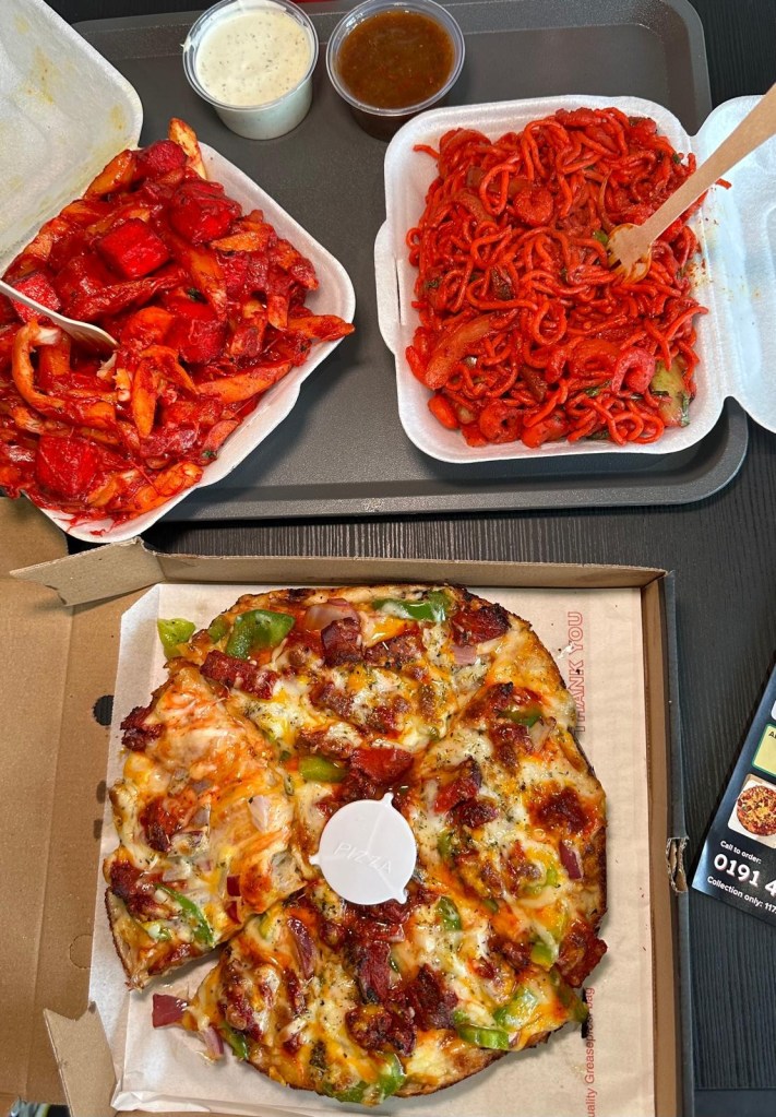 A feast of cheesy pizza, crispy loaded fries, and flavorful Indian-style noodles served together.